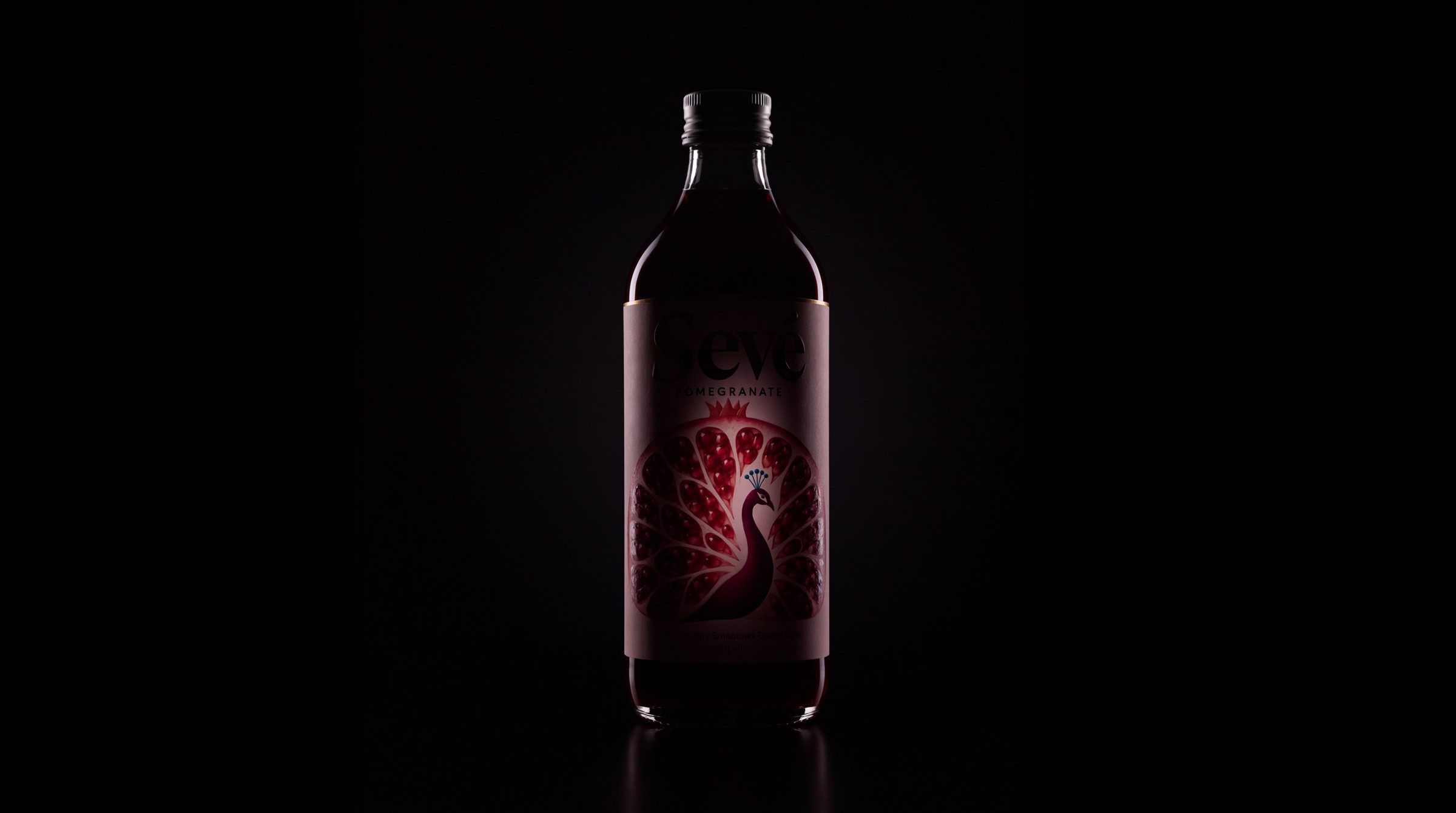 SEVÉ pomegranate bottle emerging from darkness